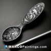 A pretty silver spoon with an artistic ink painting